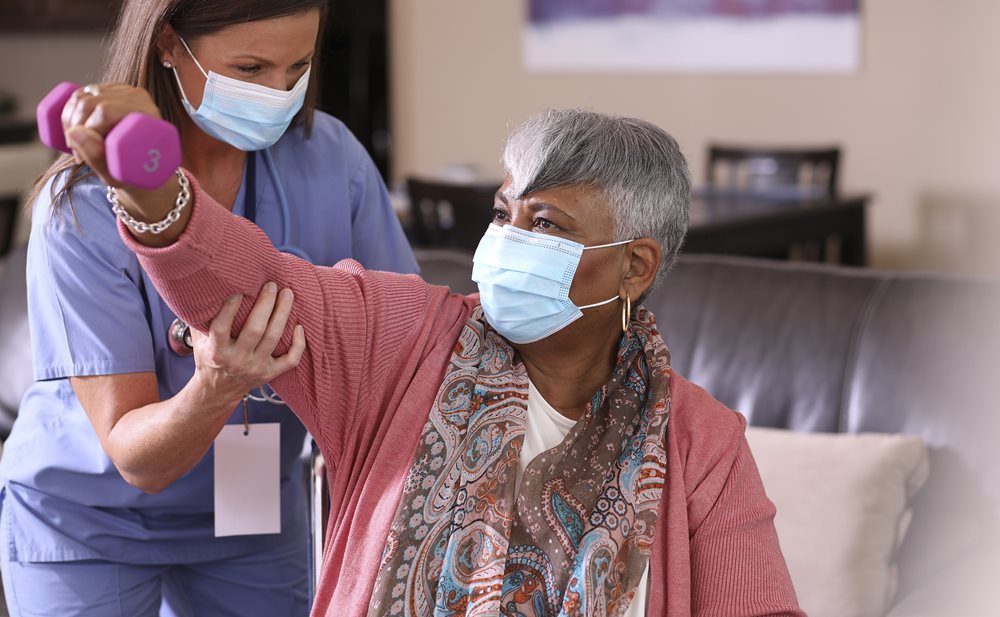 Neuro-Rehab White female therapist helps Black woman lift weight