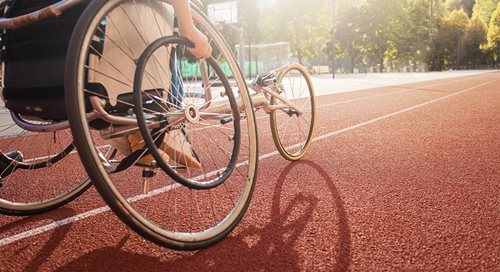 A close up of a sport-y wheelchair on a running track.