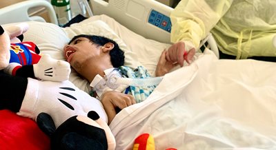 17-year-old Marcus Weir lies in his hospital bed with his Mickey Mouse stuffed toy.