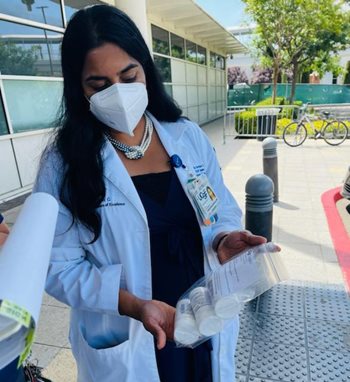 Dr. Geetha Sivasubramanian displays a clear plastic bag with vials of medicine in them