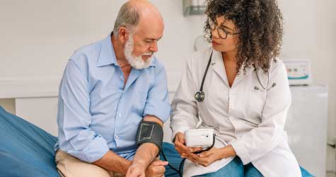 Doctor checking patients blood pressure